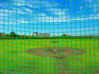 Obraz premium バックネット越しに見る初夏の平日の江戸川河川敷風景