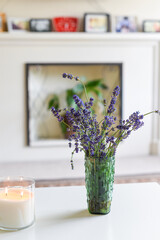Modern home interior of living room with scented candle and lavender flowers on coffee table