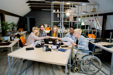 Office life, business meeting. Multicultural group of creative young coworkers discussing business...