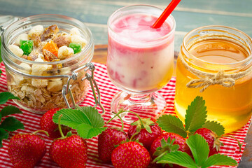 Sweet strawberry and healthy, wholesome food in composition on the table.