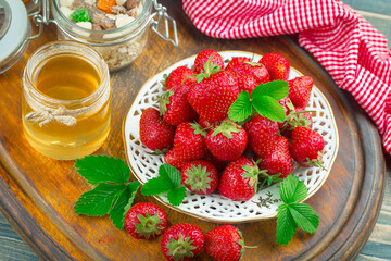 Ripe, fresh strawberries in a bowl on an old background.