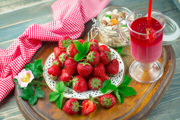 Ripe, fresh strawberries in a bowl on an old background.