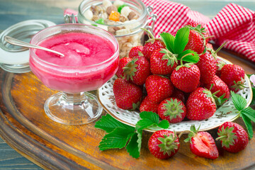 Ripe, fresh strawberries in a bowl on an old background.