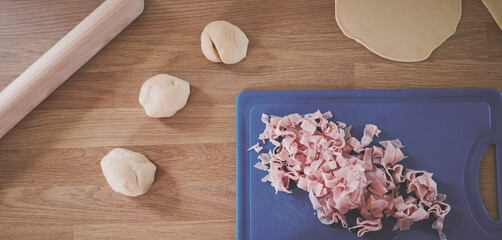 Bun dough and ham in a wood table