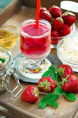Fruit cocktail from fresh strawberries on the kitchen table.