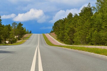 Asphalt road, bike path and sidewalk on hilly terrain.