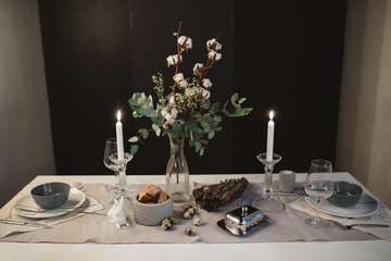 candlelight dinner for two with bread on a white table with cutlery