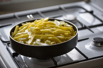 Fried potato dish on a gas stove in the kitchen