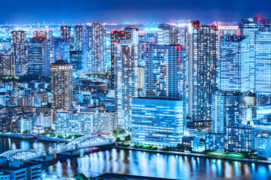 光が眩しい、東京の水辺に立ち並ぶ高層ビル群の夜景 © taka