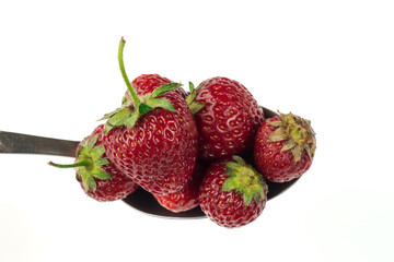 A spoon full of strawberries on a white background