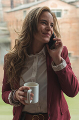 young worker talking on the phone while drinking coffee