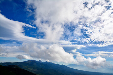 夏の青空に浮かぶたくさんの白い雲、深緑に覆われた南八ヶ岳。 The blue sky & white clouds & Yatsugatake mountain range covers in dark green.
