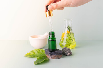 Natural skincare beauty product and alternative medicine concept- Scientist extracting organic herbal essential oil/serum w/ glassware in laboratory. Research and development of cosmetic and medicine.