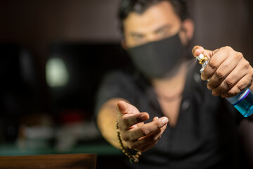 mask man using hand sanitizer in coronavirus pandemic