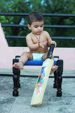 Cute Indian Child Playing With Bat