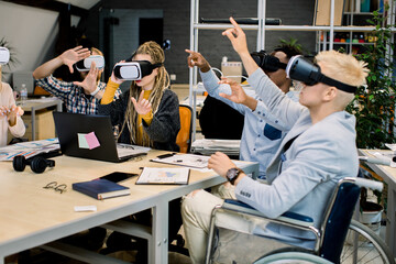 Team of multiethnic cheerful young casual business people in vr headsets gesturing and touching air...