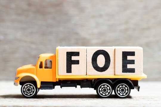 Truck hold letter block in word fpe on wood background