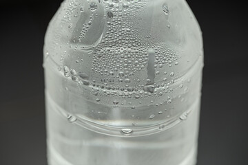 Cool water and water drop on plastic bottle with blurred background. Selective focus. Macro picture