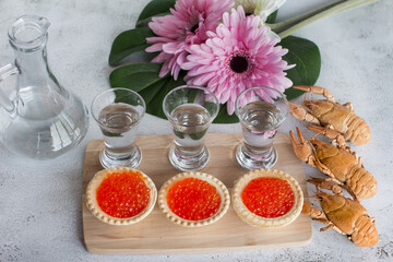 a glass of vodka and a light snack. Boiled crawfish red caviar.