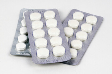 three packs of white tablets in blisters on the white background