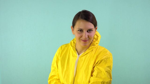 Cheerful and smiling cleaning lady in a yellow suit on a blue background. The concept of professional house cleaning. A cheerful cleaner drives the broom across the screen, cleansing of dirt.