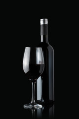 Glass of red wine next to a bottle isolated on black background