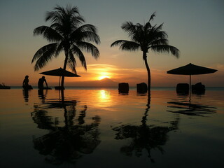 Fototapeta na wymiar Sunset framed by palm trees