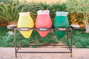 three bins for recycling. sorting debris - plastic, glass and paper. Closeup photo of colorful pots...