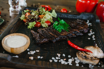 Serving meat dishes. Beef steak with vegetables