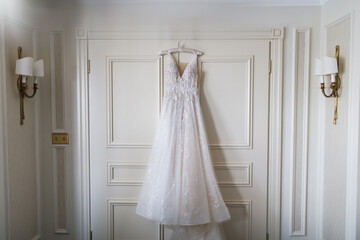 Wedding dress hanging on the door.