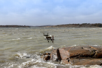 Fototapeta na wymiar An old jetty with a rocky foreground in a storm