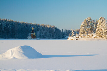 Fototapeta na wymiar Beautiful winter wonderland scenery in the Vuoxa lake with church of St. Andrew's.