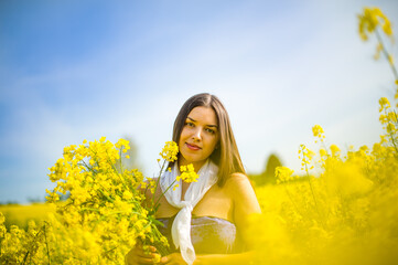 pretty girl in a good mood walks in a rape field