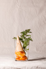 Vegan vegetable carrot ice cream sorbet with waffle cone on beige textile background.Healthy eating concept.Fashion food composition