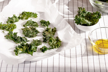 Healthy snack kale chips with salt and seasoning on a baking paper.Low-carb and gluten free vegetable crisps snack.Horizontal orientation