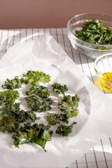 Healthy snack kale chips with salt and seasoning on a baking paper.Low-carb and gluten free vegetable crisps snack.Vertical orientation
