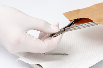 Hands taking manicure tools from craft envelope before manicure procedure.