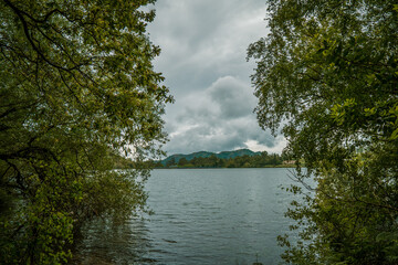 lago con cielo nublado y arboles rodeando