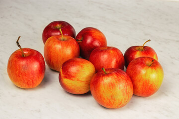 Red apples lie on a light table. Close up