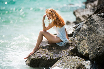 Beautiful redhead at the sea. Woman sensual. Beautiful young woman relaxing on beach.