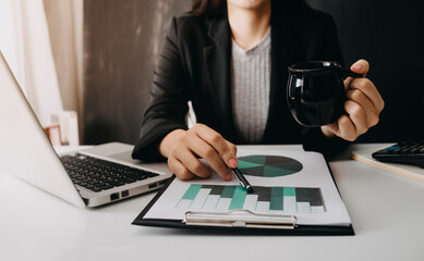 Fototapeta premium womman using laptop and typing and holding coffee cup in cafe, home office in morning light