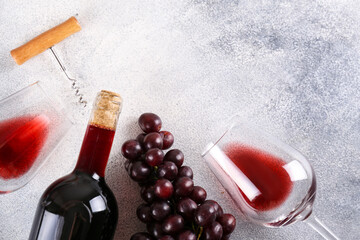 Flat lay composition with two glasses of vintage red wine, bunch of grapes & corkscrew on grunged concrete table background. Expensive bottle of cabernet sauvignon concept. Copy space, top view. - obrazy, fototapety, plakaty