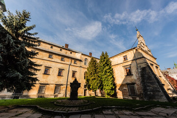 interior yard of bernardine monastery with green firs against blue sky in lviv, ukraine