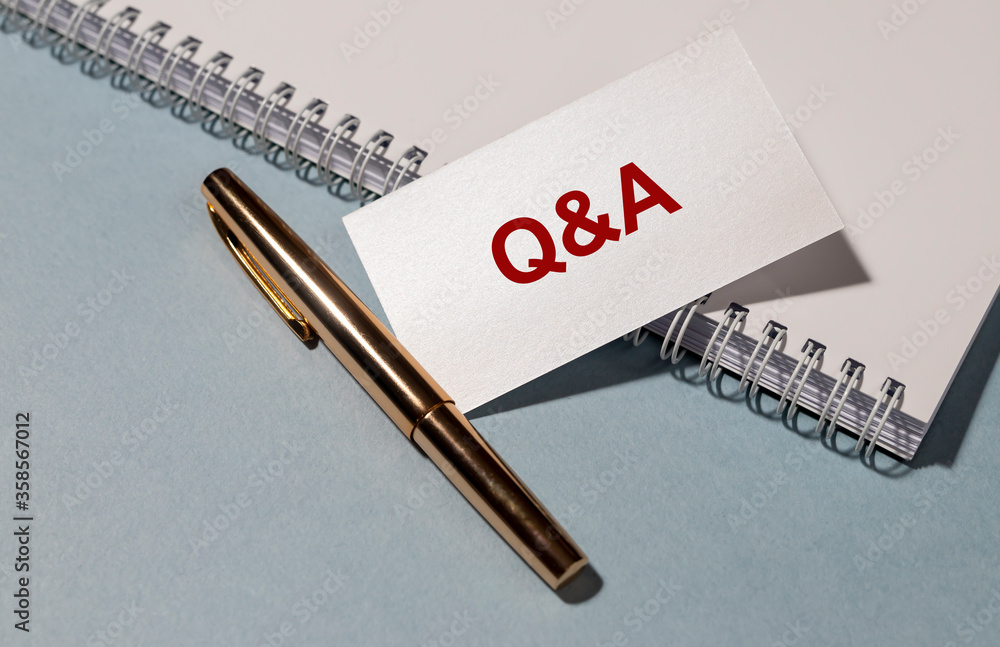 Poster concept q&a questions and answers message on note paper card on blue office table with pen and spira