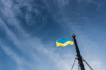low angle view of ukrainian flag on flagpole against blue sky in lviv, ukraine