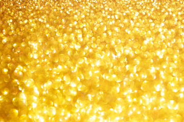 Golden sparkle glitters with bokeh effect and selectieve focus. Festive background with bright gold lights, champagne bubble. Christmas mood concept. Copy space, close up, texture, top view.