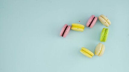 Macaroons or macaron lay in heart shape on pastel blue surface. Close up.