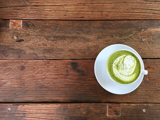 Top view of green tea latte on wood table with copy space