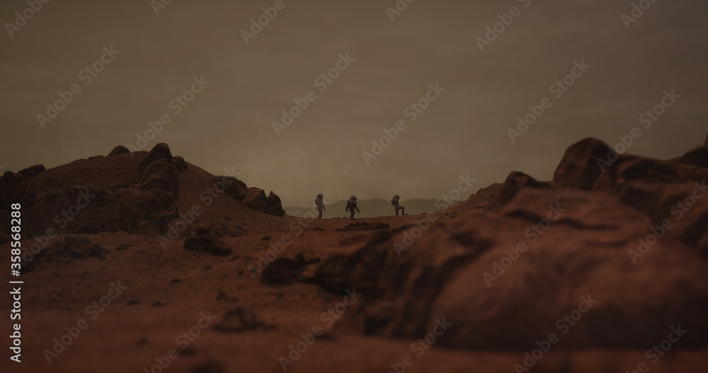 Wall mural three astronauts walking on a surface of a red rocky planet. mars colonization concept. planet creat