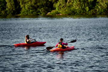 Two girls in a canoe-polo helmet rowing with weights and swimming on water. canupolo. in the rescue...